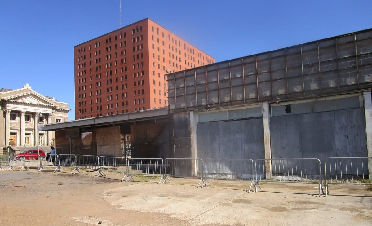 Vacant commercial building in downtown Shreveport behind a temporary fence before demolition