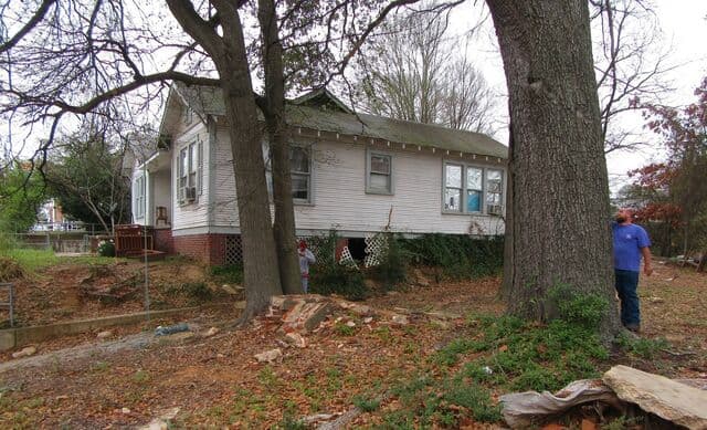 Brick and concrete foundation debris on a corner lot across the street from a school